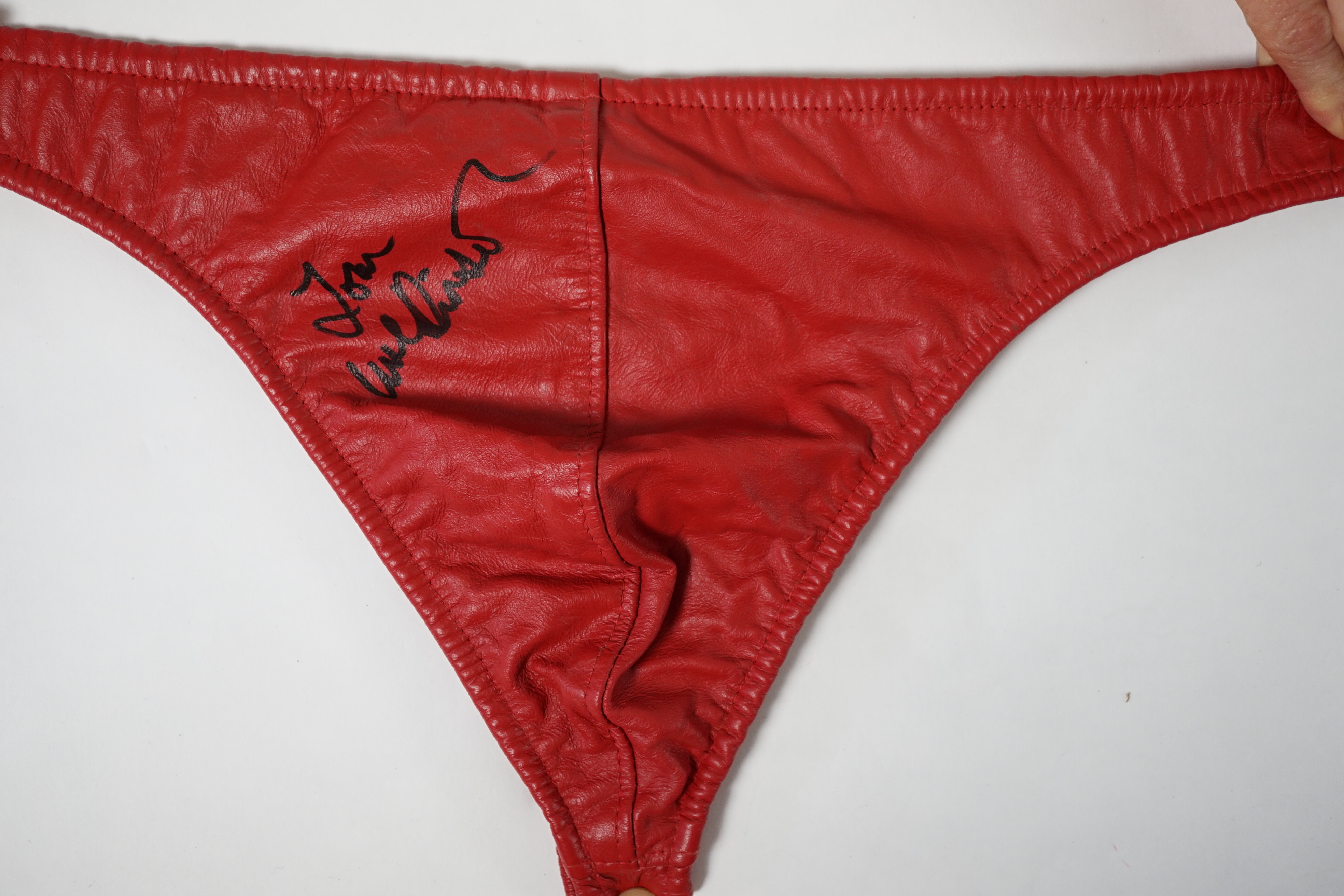 A red leather thong, as worn by Tom Wilkinson in the film The Full Monty and signed by him, together with a signed note confirming authenticity.